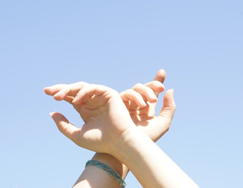 person holding hands with blue manicure