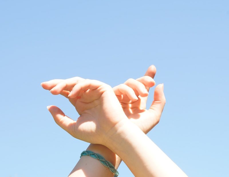 person holding hands with blue manicure